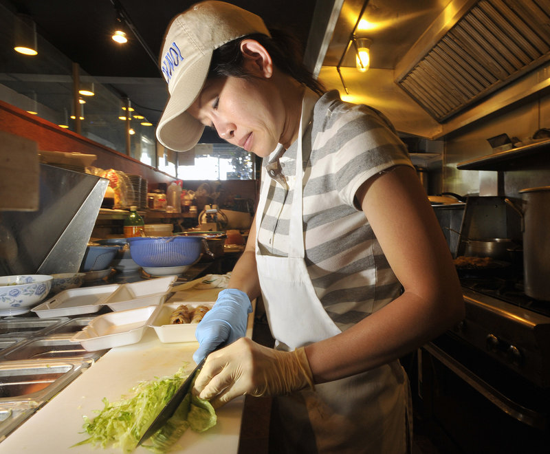 Lan Nguyen chops vegetables for a takeout order at the Pho Hanoi restaurant on Ocean Street in South Portland.