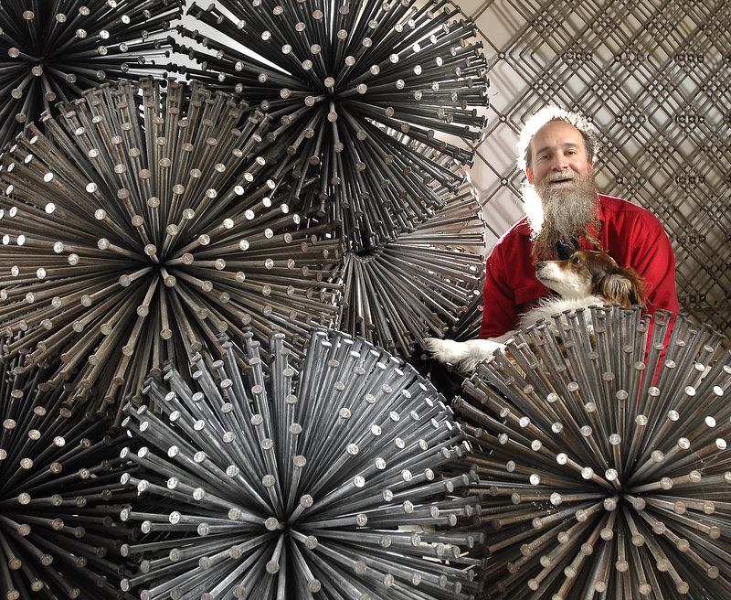 John Bisbee poses with some of his nail sculptures for a 2008 exhibition of his work at the Portland Museum of Art.