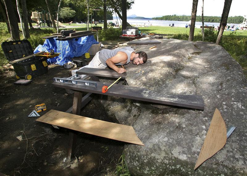 Wade Kavanaugh checks the fit of a table that will use as part of its base one of the huge glacial boulders that dot the park.