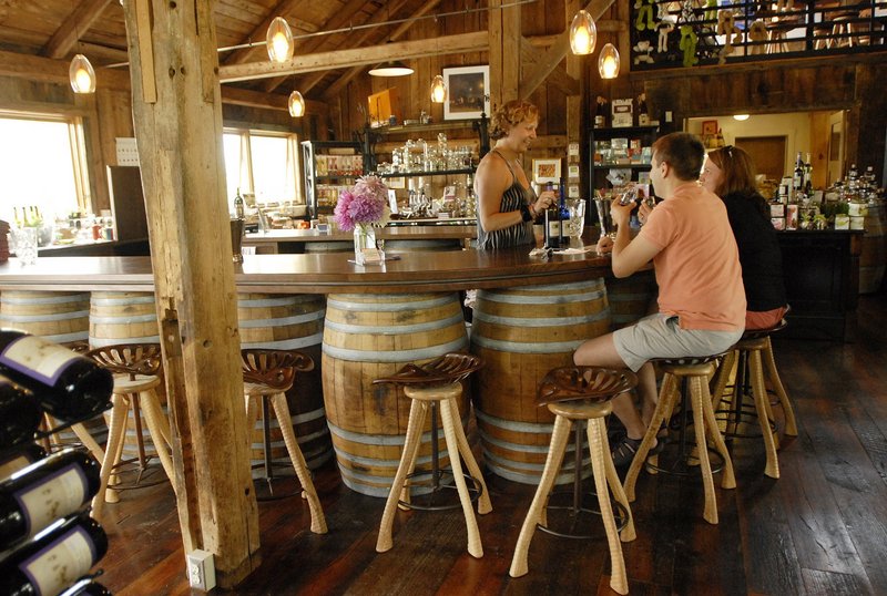 Cellardoor Winery owner Bettina Doulton visits with Kimberly and Aaron Preston of Denver, Colo., in the Lincolnville barn that she renovated to house the business.