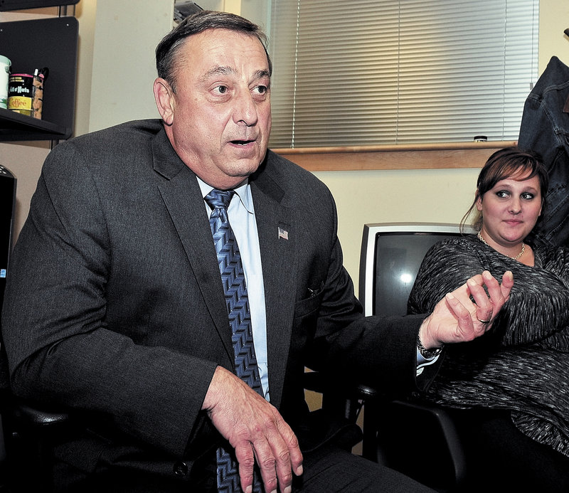 Republican gubernatorial candidate Paul LePage speaks with reporters in the Cross Building behind the State House in Augusta. At right is his daughter Lauren LePage.