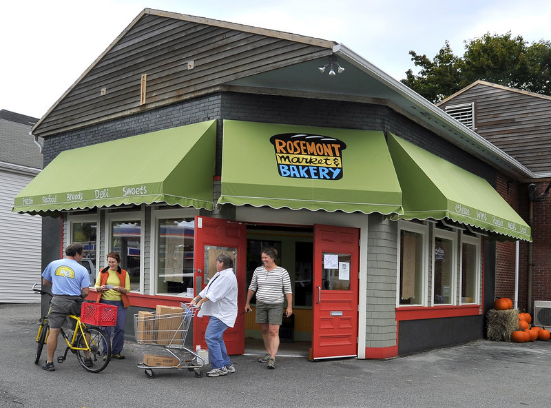 Owners and employees of the Rosemont Market and Bakery use bikes, shopping carts, and arms to move product Wednesday to the market’s new location across the street.