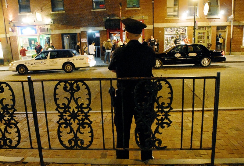 A Portland Police officer watches the crowds on the sidewalk along Fore Street in the Old Port. It doesn't seem that Portland needs the help of the Guardian Angels, whose leader plans to come to Portland this month to start a chapter.