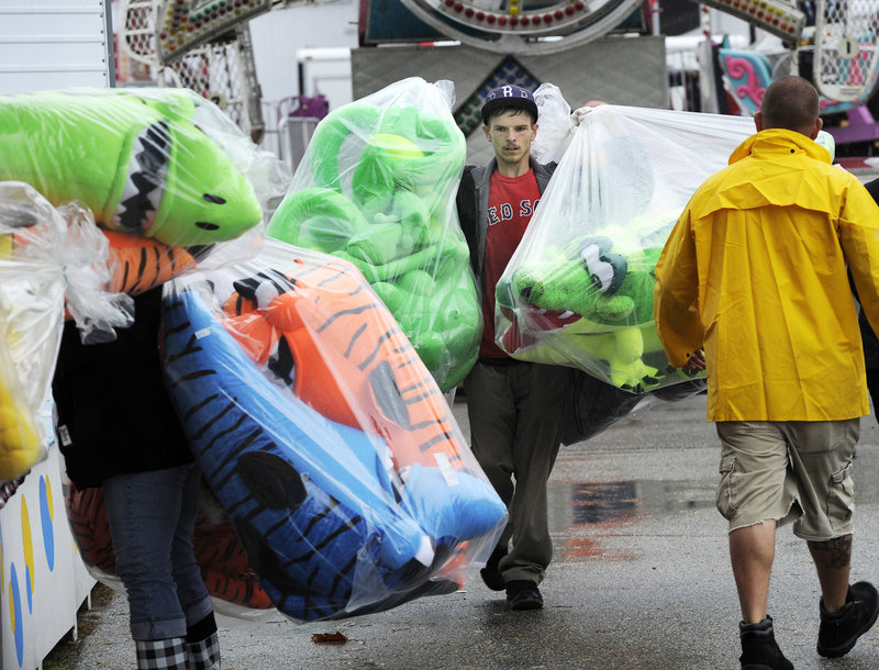 Anthony Halgas carries stuffed animals as he helps stock the midway skill games with prizes. On Monday, the fair hosts the popular Woodsman’s Field Day, with dozens of sawing, rolling and felling competitions