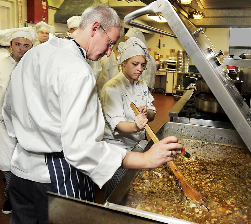 Chef Michael Ruoss adds Tabasco sauce to seafood gumbo being prepared Thursday in the Southern Maine Community College kitchen for the Harvest on the Harbor Food and Wine Festival. Valerie Wacenske, a culinary arts student at SMCC, helps stir.