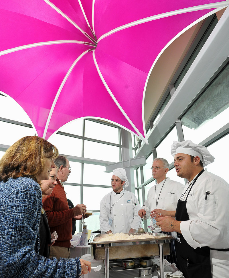 Chef Michael Ruoss, center right, serves seafood gumbo to festival guests with the help of culinary students Michael Lemieux, center, and Josh Gray, right.