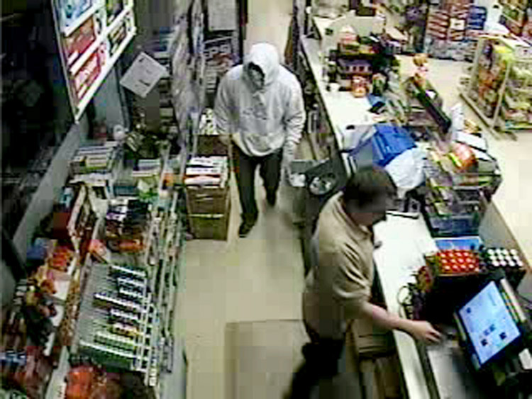Security camera photo shows robbery suspect wearing hooded sweatshirt.