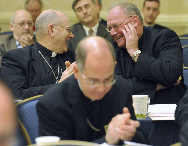 Bishop Roberty Vasa, left, of Baker, Ore., congratulates Archbishop Timothy Dolan, right, of New York after Dolan was elected president of the U.S. Conference of Catholic Bishops during the conference's annual fall meeting today.