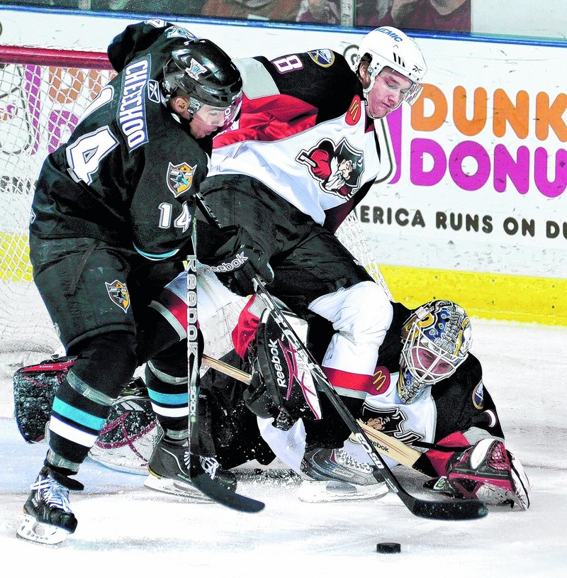 Portland goalie Jhonas Enroth keeps his eyes on the puck as Jonathan Cheechoo battles with Portland's Dennis Persson.