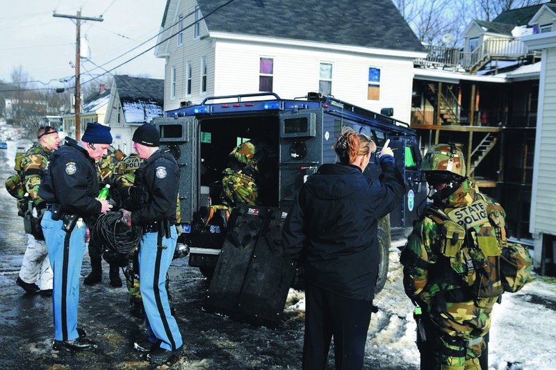 State police confer outside an Augusta apartment building after Peter Bathgate was arrested Tuesday. He is charged with killing Paul Allen, 47, whose body was found Sunday in Hallowell.