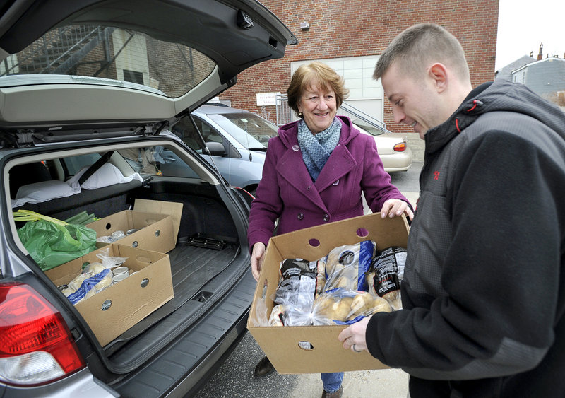 Portland City Councilor Cheryl Leeman delivers food to John Myrick on Monday for the Christmas Day dinner. Organizers and businesses also pitched in with contributions of food, money and outdoor gear.