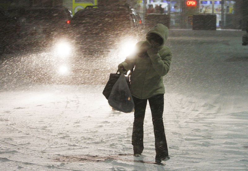 Elizabeth Kistoglou of Watertown, Mass., walks through a heavy snowfall as she leaves work at Shoppers World in the Boston suburb of Framingham, Mass., Sunday. Maine is expected to receive 12 to 18 inches of snow from the blizzard working its way up the East Coast.