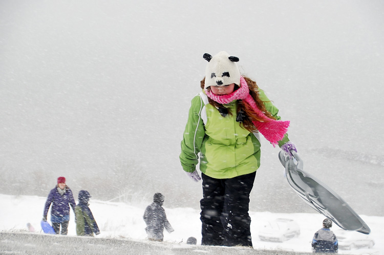 Adara Bankhead, 10, of Portland hangs on to her sled in the fierce wind and snow today on the Eastern Prom as she climbs the hill for another run. She was there with her family.