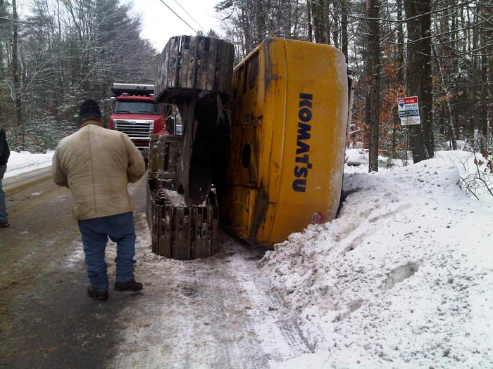The excavator slipped off an icy trailer when it was being unloaded. The operator escaped uninjured.