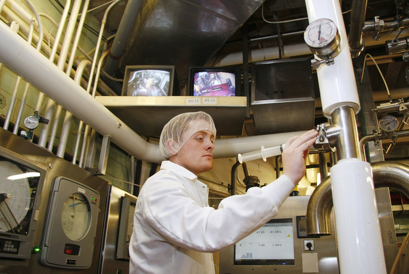 Jeff Averill takes milk samples for quality testing at Oakhurst Dairy in Portland. Each day, 10 tanker trucks deliver milk to the plant.