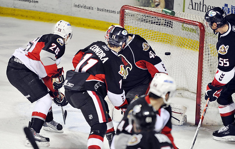 Portland’s Brian Roloff, left, beats Binghamton goalie Robin Lehner for a goal as Senators Eric Condra, center, and defenseman David Hale look on Tuesday night. The Senators won 5-2, snapping Portland’s win streak at three games.