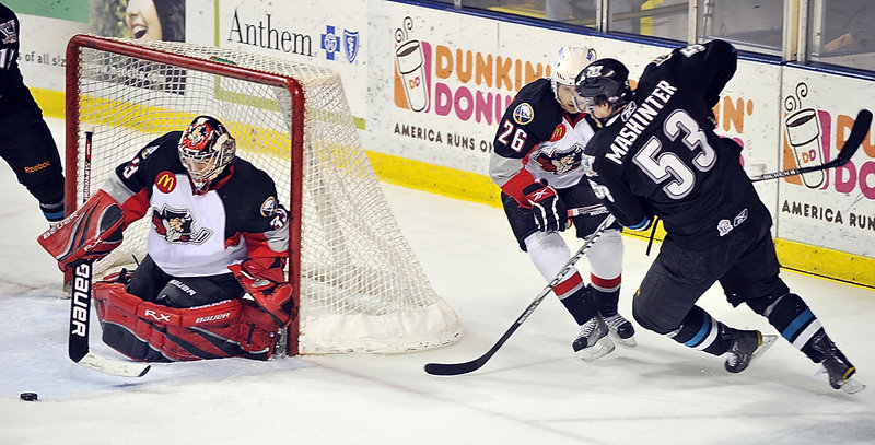 Pirates goalie David Leggio keeps his eye on the puck as Brandon Mashinter of Worcester sends it into the crease. Maxime Lagault defends.