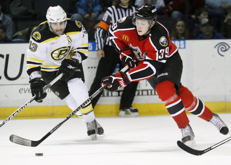 Kirk MacDonald of Providence works with the puck as Portland's Luke Adam closes in during the Pirates 5-2 win Saturday. Mark Mancari scored three goals for Portland.