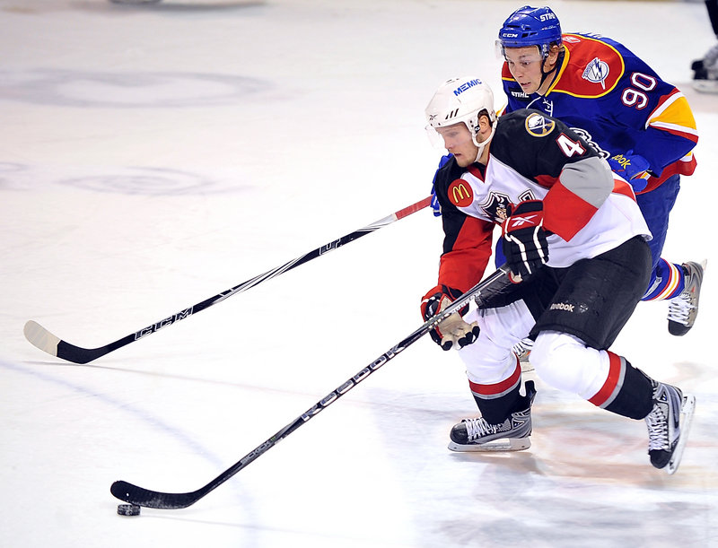 Portland’s Alex Biega tries to break away from Norfolk’s Johan Harju in the first period. Call-ups and injuries shortened Portland’s bench for the game.