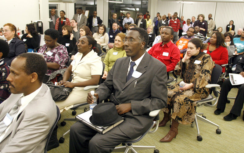 Ruben Ruganza, middle, of Portland listens to speaker Regina Phillips during a night of networking Thursday. Ruganza has a bachelor’s degree in hospital management and a teaching certificate, but has been unable to find a professional job.