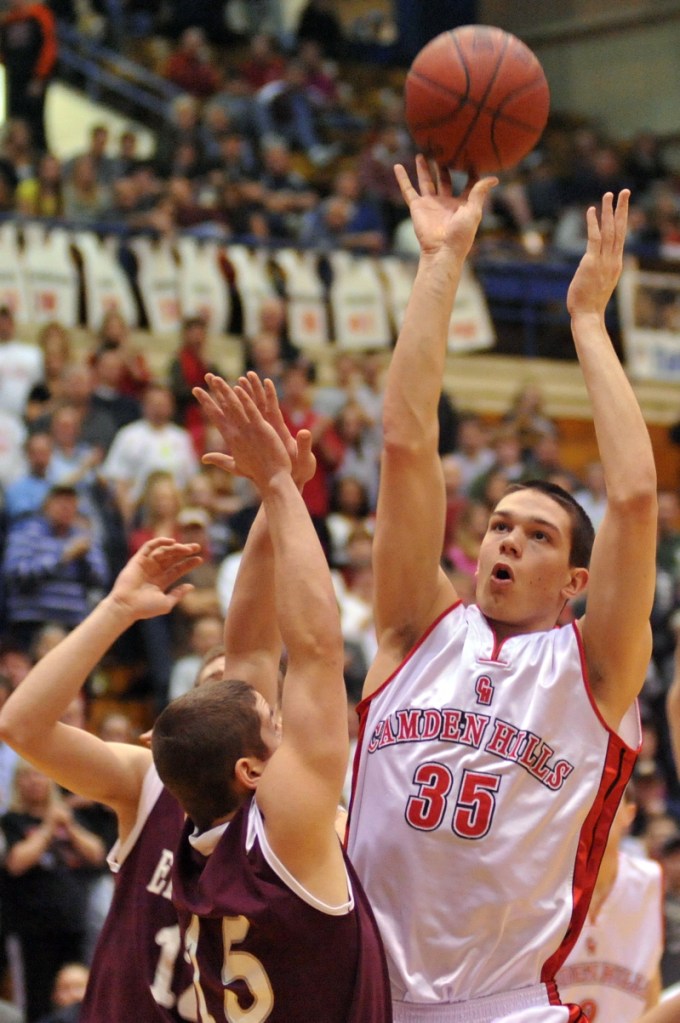Tyler McFarland of Camden Hills shoots over Jordan Carter of Ellsworth.