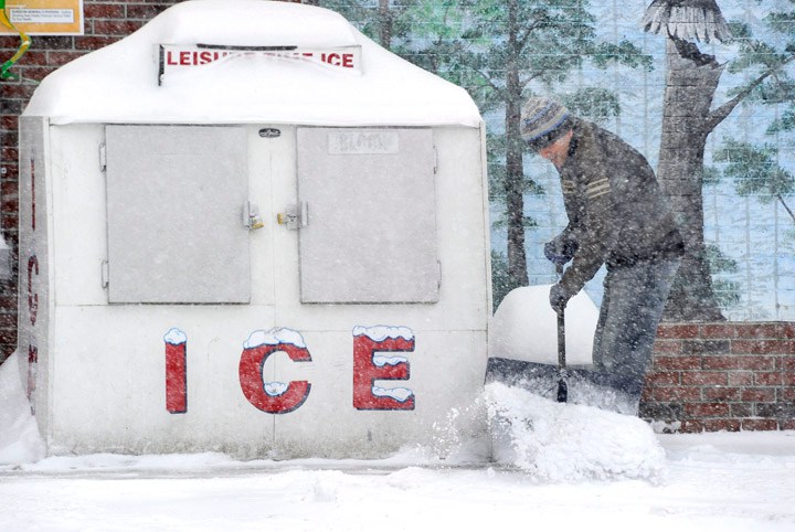Ice and snow are plentiful today as Mohsen Latifi shovels a path to an ice machine at Friendly Discount redemption center in Westbrook.