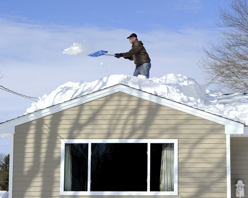 Alan LeVitre shovels snow off his house along Mayflower Street in Westbrook on Friday. Emergency officials are warning Mainers to be aware of the possible dangers that come with snowfall on roofs.
