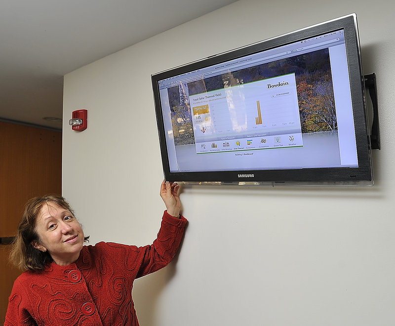 Catherine Longley, a Bowdoin administator, shows the Lucid Building Dashboard, an energy monitor that displays the Btus being consumed by the heating system at Thorne Dining Hall on campus.