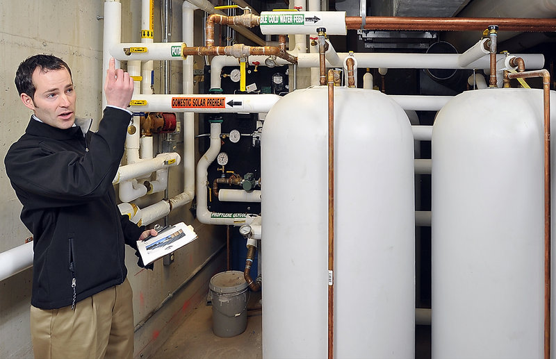Daniel Welch, Bowdoin’s maintenance project manager, describes how Thorne Dining Hall’s water is heated by solar panels, one of several energy system upgrades meant to reduce the Brunswick school’s carbon footprint.