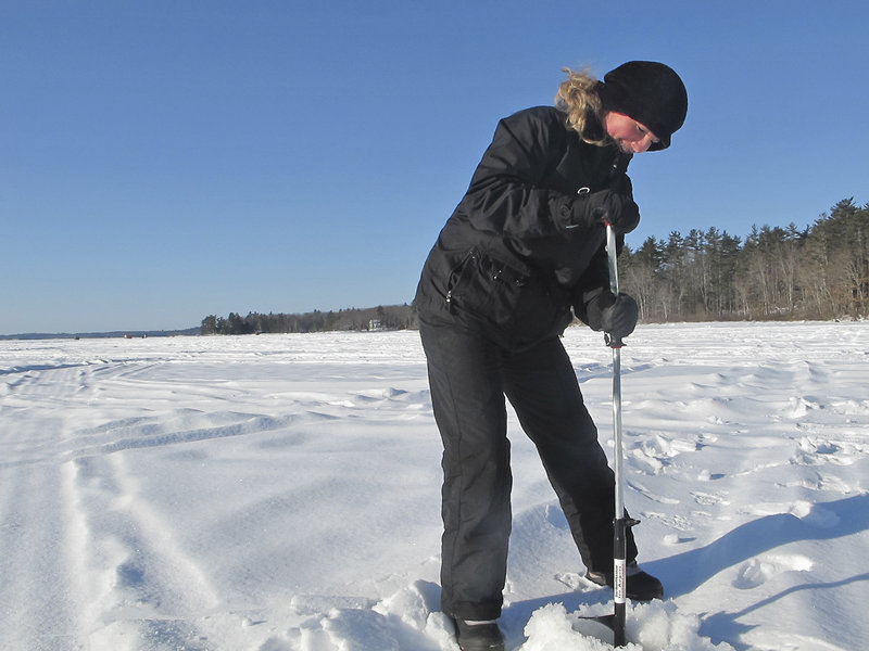 Reporter Shannon Bryan uses a hand auger to drill a hole in the ice on Sebago Lake in Raymond.