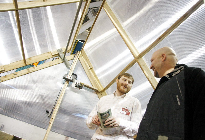 Eric Winters of Maine Garden Products shows Sam Miller, right, of Cornish around a greenhouse that does the watering for you.