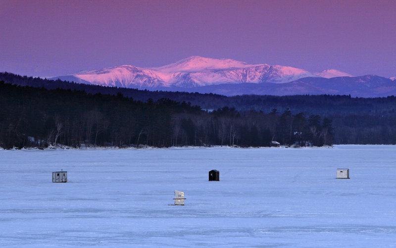 Morning alpenglow casts a warm light on 6,288-foot Mount Washington, in New Hampshire’s White Mountains, 40 miles to the west of a group of ice-fishing shacks on Long Lake in Naples on Thursday.