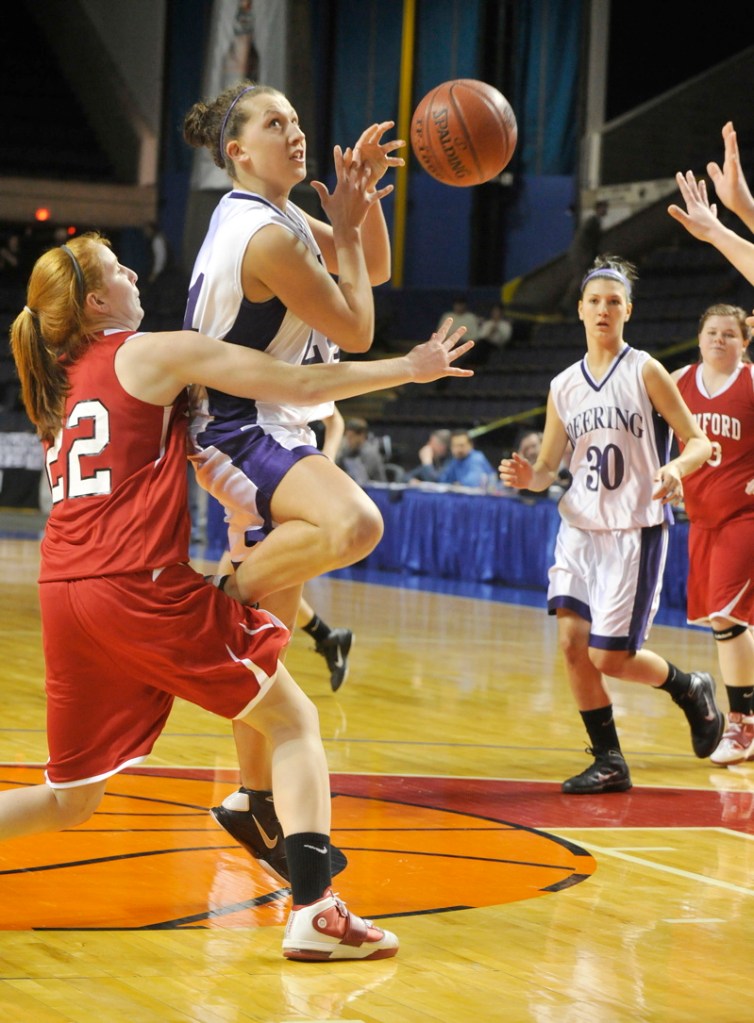 Ella Ramonas of Deering has the ball knocked loose while driving against Heather LeBlanc of Sanford as Aarika Viola of Deering moves in. Deering won the Class A semifinal.