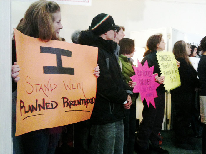 Members of the Maine Choice Coalition, including Lizzy Reinholt of Stratton, foreground, hold a press conference today in response to the proposed elimination of a family planning program known as Title X. The program helps pay for birth control, screening and treatment for sexually transmitted diseases and pre-natal care for low income women. The press conference took place at First Parish Unitarian Church in Portland.