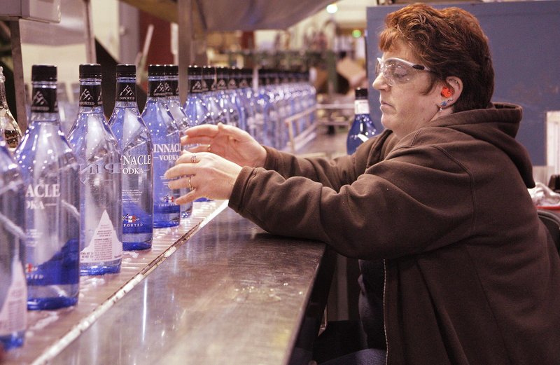 Cynthia Fisher checks labels and the fill levels of bottles of Pinnacle Vodka at White Rock Distilleries in Lewiston.