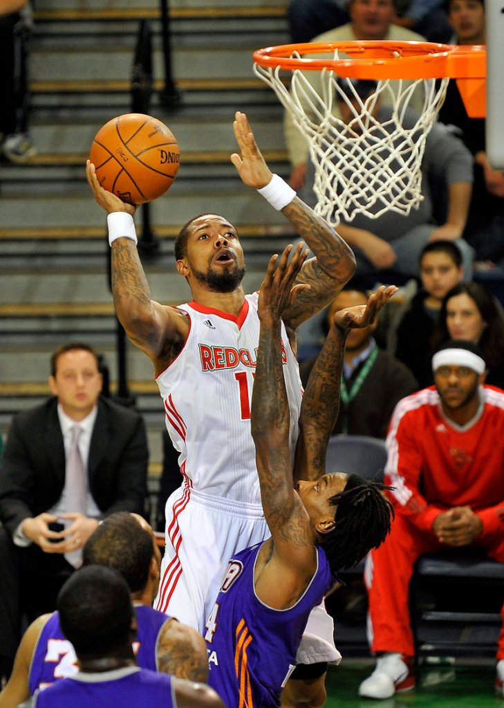 Antonio Anderson of the Red Claws keeps his focus while putting the ball over Mike Taylor of Iowa.