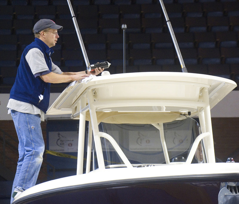 Mike Sullivan, from the Yarmouth Boat Yard, puts the finishing touches on the hardtop of a 28-foot Pursuit powerboat before the show opens Friday.
