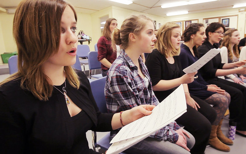 Kristen Stearns, left, a junior at the University of Southern Maine School of Music and a member of the USM Chamber Singers, sings alongside Elise Schwebler, a Kennebunk High School freshman, on Wednesday. The USM singers are on tour to showcase their school.