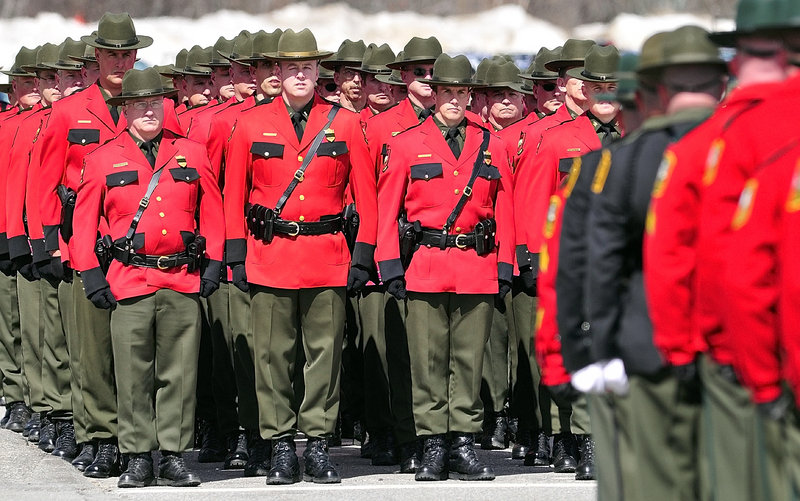 Maine game wardens in full dress uniforms gather at the service for pilot Daryl Gordon at the Augusta Civic Center.