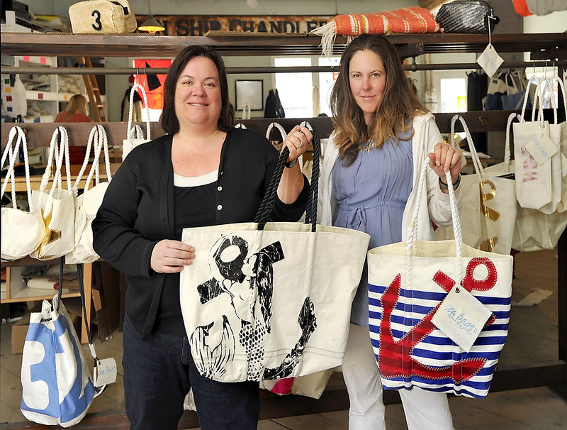 Seabags co-owners Beth Shissler, left, and Hannah Kubiak show some of their favorite tote bags in front of their retail display.