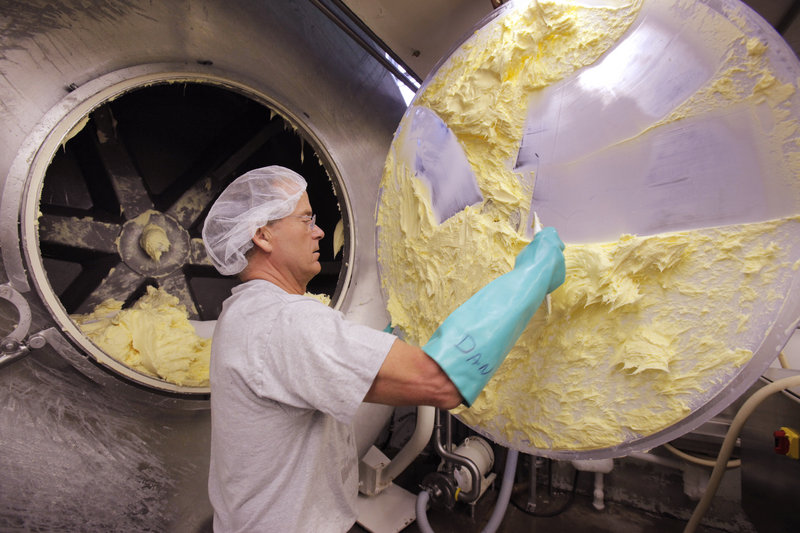 Daniel Patry scrapes butter off the door to a churn at Kate’s Homemade Butter in Old Orchard Beach.