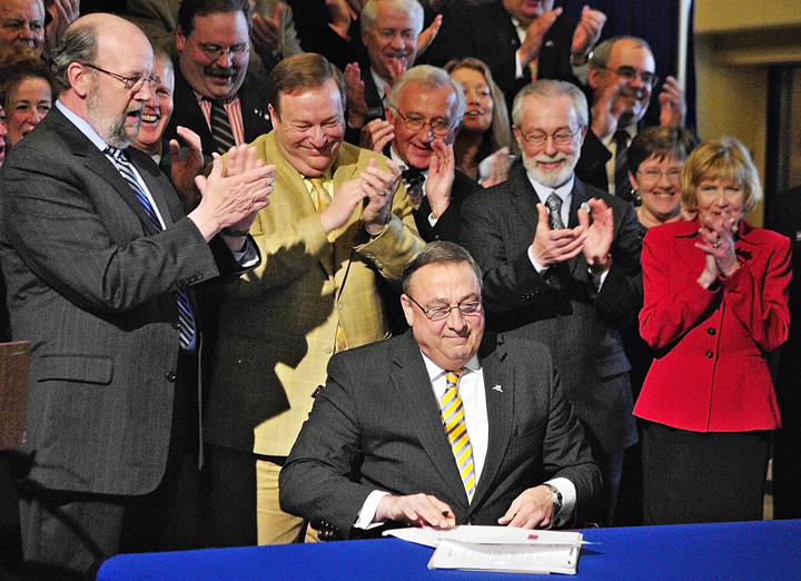 Gov. Paul LePage, is applauded after signing the ambitious GOP health insurance reform bill, L.D. 1333. into law today. About 75 Republican lawmakers stand behind him in the Hall of Flags at the State House. Standing immediately behind him, from left, are: Speaker of the House Bob Nutting, R-Oakland; Senate President Kevin Raye, R-Perry; Rep. Wes Richardson, R-Warren; Sen. Rodney Whitemore, R-Skowhegan; Rep. Joyce Fitzpatrick, R-Houlton; and Sen. Lois Snowe-Mello, R-Poland.