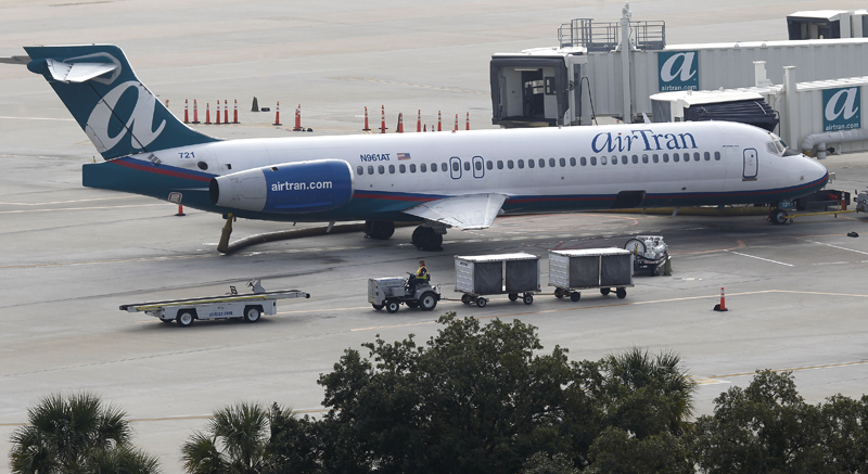 A Jan. 20, 2011, photo of AirTran Airlines baggage workers preparing to load a Boeing 717 at the Tampa International Airport in Tampa, Fla.