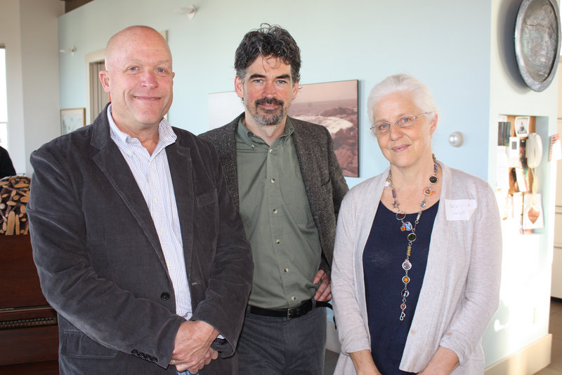 Singer-songwriter Slaid Cleaves stands between party hosts Cyrus and Patty Hagge in the living room of the Hagges Munjoy Hill home.