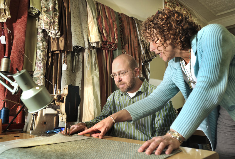 Dana Ben, a seamstress at The Drapery Trading Co., instructs Ray Routhier on how to use a sewing machine.