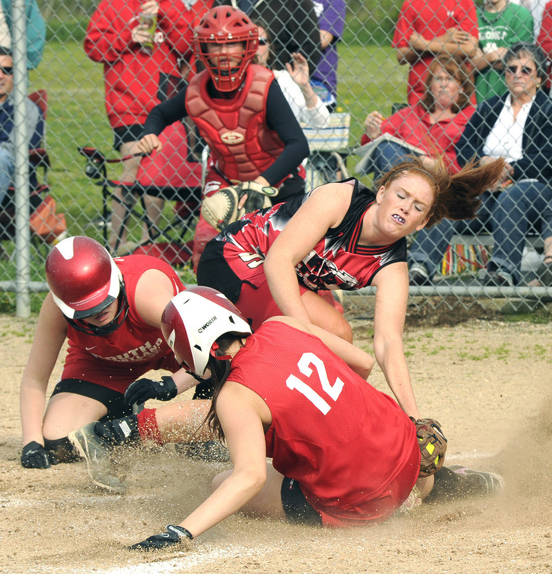 Stephanie McDonough scores for South Portland as Scarborough pitcher Mo Hannan applies a tag Tuesday. McDonough scored after a throw home got away in an attempt to get Libby Grant, left, who scored first.