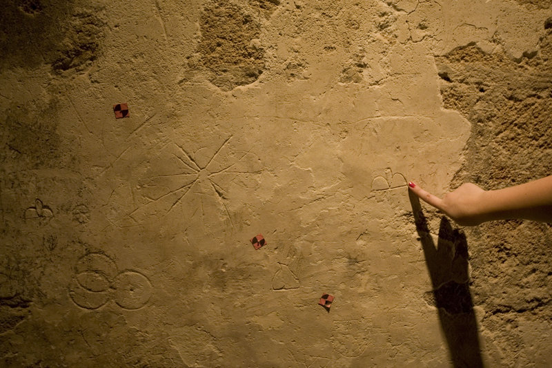 Graffiti left by a medieval traveler is pointed out on a wall in Acre. The newly excavated area, part of a Crusader neighborhood, is set to open later this year.