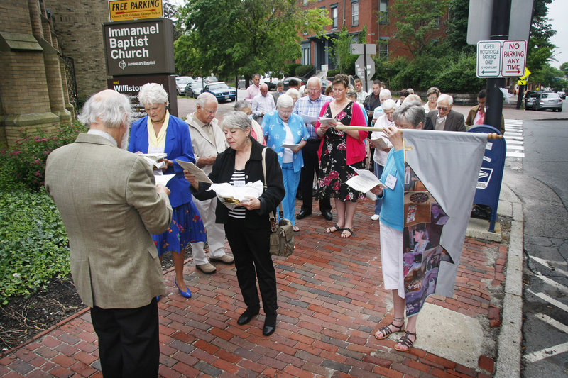 The Rev. Milton Ryder, far left, leads the litany Sunday for the congregation of Immanuel Baptist Church before a special service merging Immanuel and Williston-West Church into one.