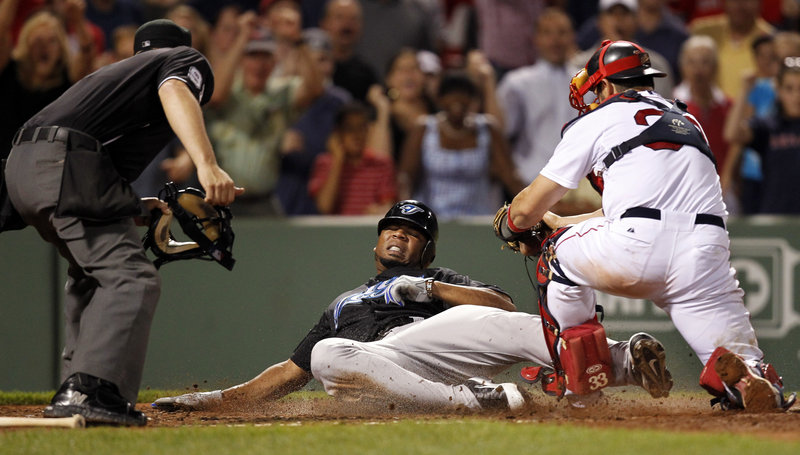 Jason Varitek of the Boston Red Sox prepares to plant the tag on Edwin Encarnacion of the Toronto Blue Jays, ending the game on umpire Brian Knight’s out call. The Red Sox held on for a 3-2 victory at Fenway Park.
