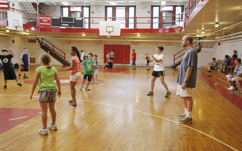 Reporter Ray Routhier, far right, stands on the sidelines with Keera Allen as she referees a game of pin guard during the South Portland rec camp at Mahoney Middle School. Routhier found the game tough to understand, as both teams can be on offense at the same time.